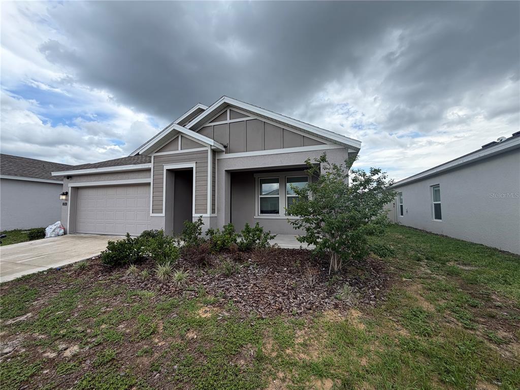 A single-story house with a gray stucco exterior, a two-car garage, and a front porch — 314 LAWSON AVENUE, HAINES CITY, FL