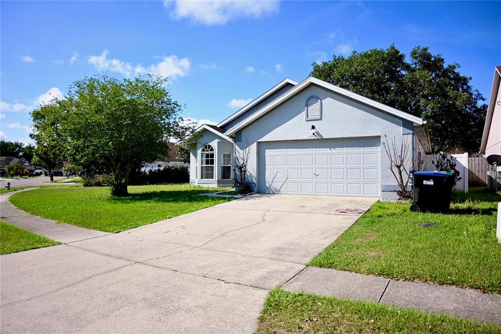 A light blue single-story house features a two-car garage and a concrete driveway — 11534 KENLEY CIRCLE, ORLANDO, FL