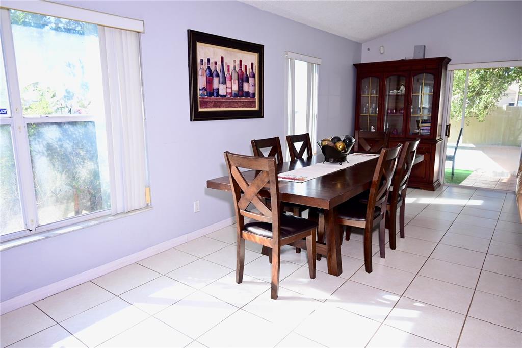 A dining room features a dark wood table with six chairs, tile flooring, and a hutch — 11534 KENLEY CIRCLE, ORLANDO, FL
