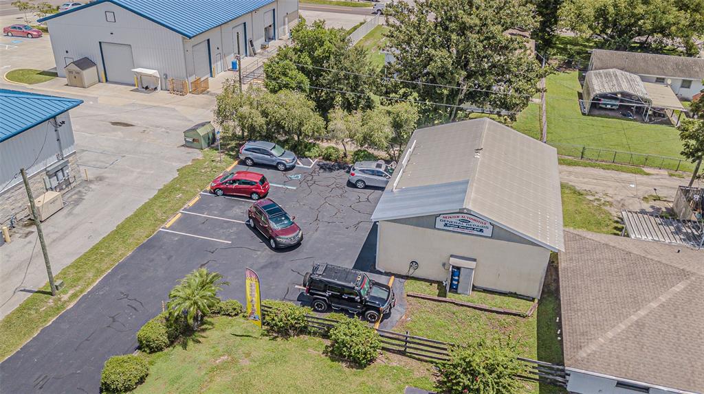 An aerial view shows a commercial building with a parking lot and several parked vehicles — 5924 7TH STREET, ZEPHYRHILLS, FL