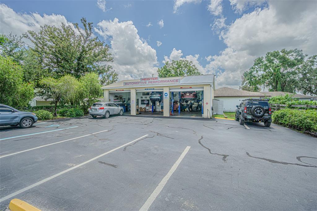 An exterior view of a three-bay automotive repair shop with a paved parking lot — 5924 7TH STREET, ZEPHYRHILLS, FL