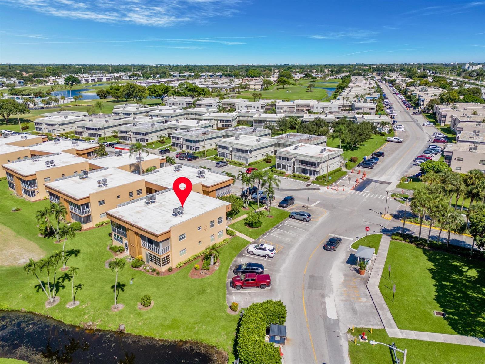 An aerial view shows a multi-story apartment building with a red location pin on top — 480 Flanders J, Delray Beach FL 33484, DELRAY BEACH, FL