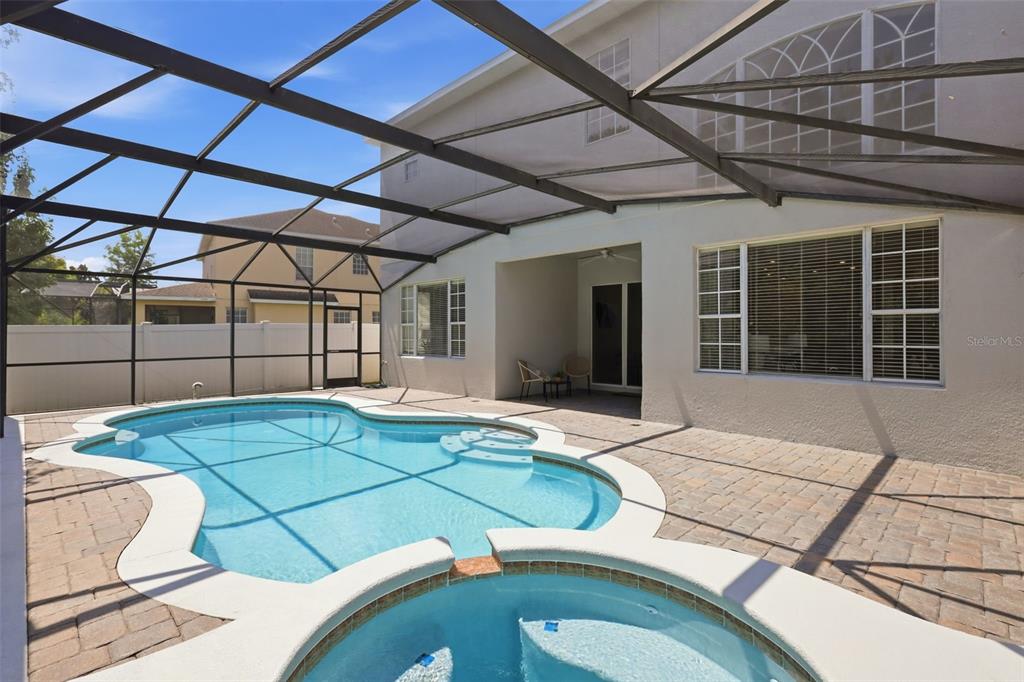 A screened-in swimming pool and hot tub on a paved patio surrounded by trees — 2555 SAND ARBOR CIRCLE, ORLANDO, FL