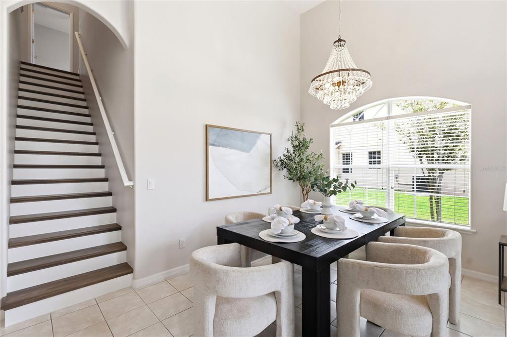 A bright, open-concept living and dining area features high ceilings, tile floors, and large windows — 2555 SAND ARBOR CIRCLE, ORLANDO, FL
