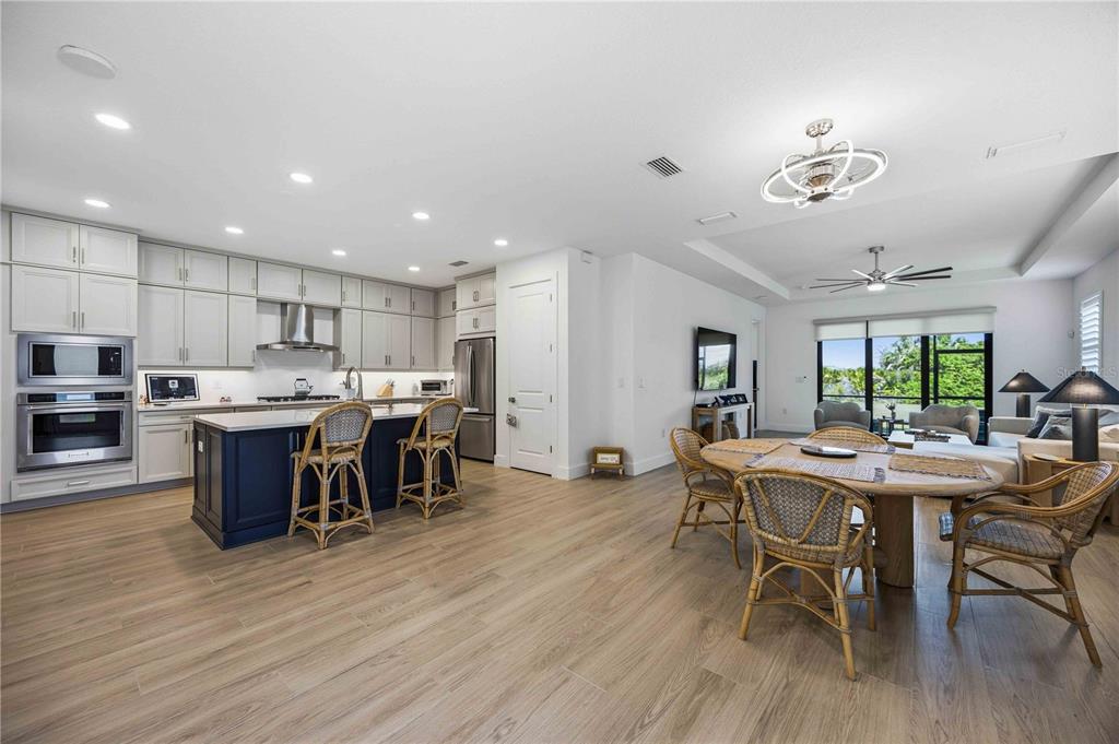 A paved walkway leads through a screen door to a covered patio with lounge chairs — 18652 DAYSPRING PLACE, VENICE, FL