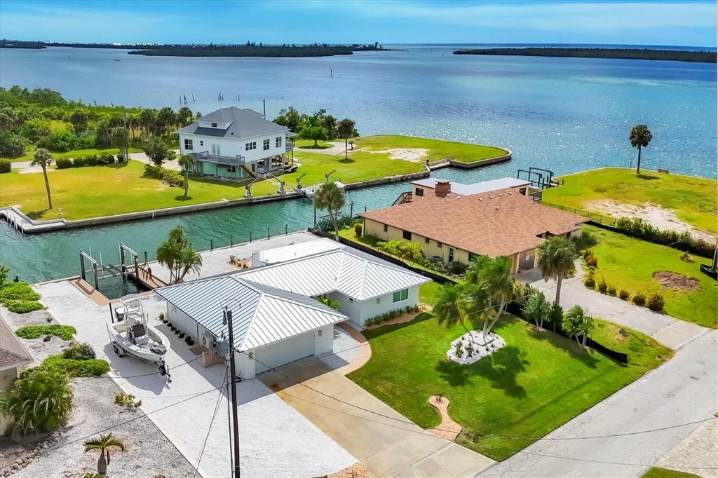 An aerial view shows waterfront homes with private docks along a canal near the ocean — 1915 PENNSYLVANIA AVENUE, ENGLEWOOD, FL