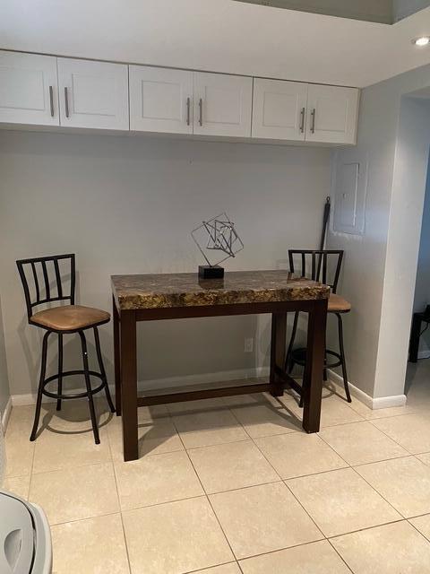 A high-top table with two stools sits beneath white cabinets in a tiled room — 209 SE 6th Street # 4, Boynton Beach FL 33435, BOYNTON BEACH, FL