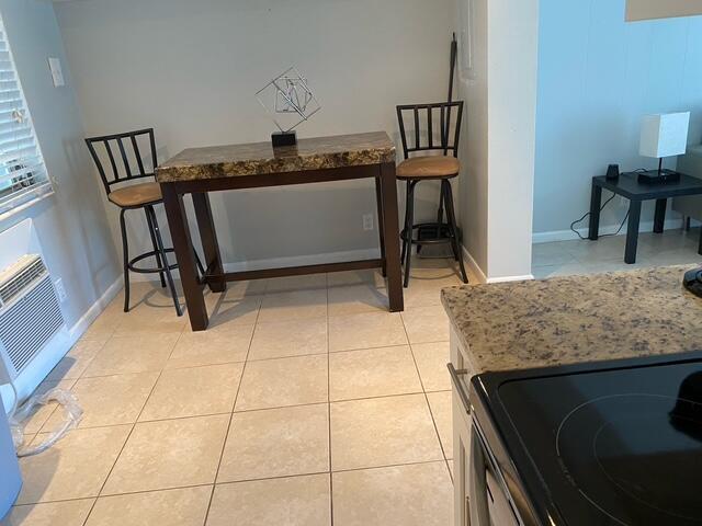 A kitchen area features a high-top table with two stools and tiled flooring — 209 SE 6th Street # 4, Boynton Beach FL 33435, BOYNTON BEACH, FL