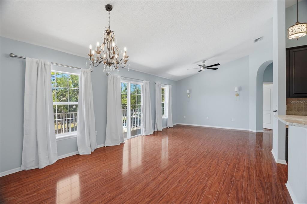 A dining room with light blue walls, wood flooring, a chandelier, and sliding glass doors — 7001 INTERBAY BOULEVARD UNIT 151, TAMPA, FL