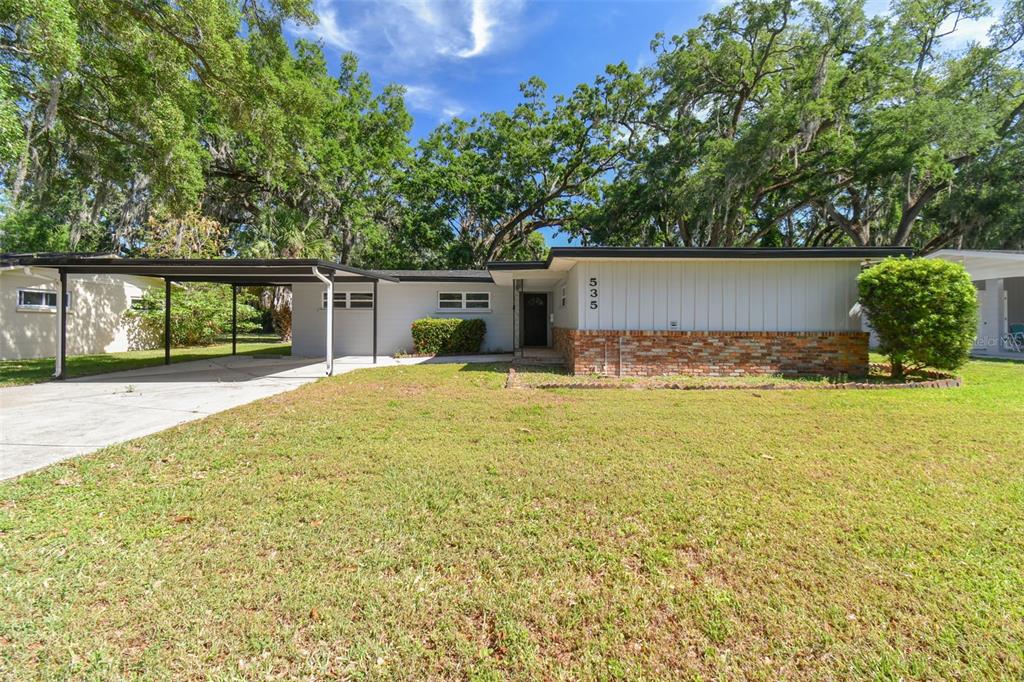 A single-story house with a brick base, light siding, and an attached carport — 535 W PALMEDEN DRIVE, LAKELAND, FL