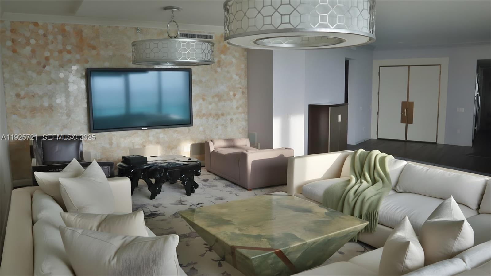 A living room features a large television, two modern chandeliers, and white sectional sofas — 10295 Collins Ave # 1203, Bal Harbour FL 33154, BAL HARBOUR, FL