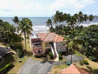 An aerial view shows a two-story house with a terracotta roof near the ocean — CANDELERO DRIVE PALMAS DORADAS UNIT 519, HUMACAO, PR