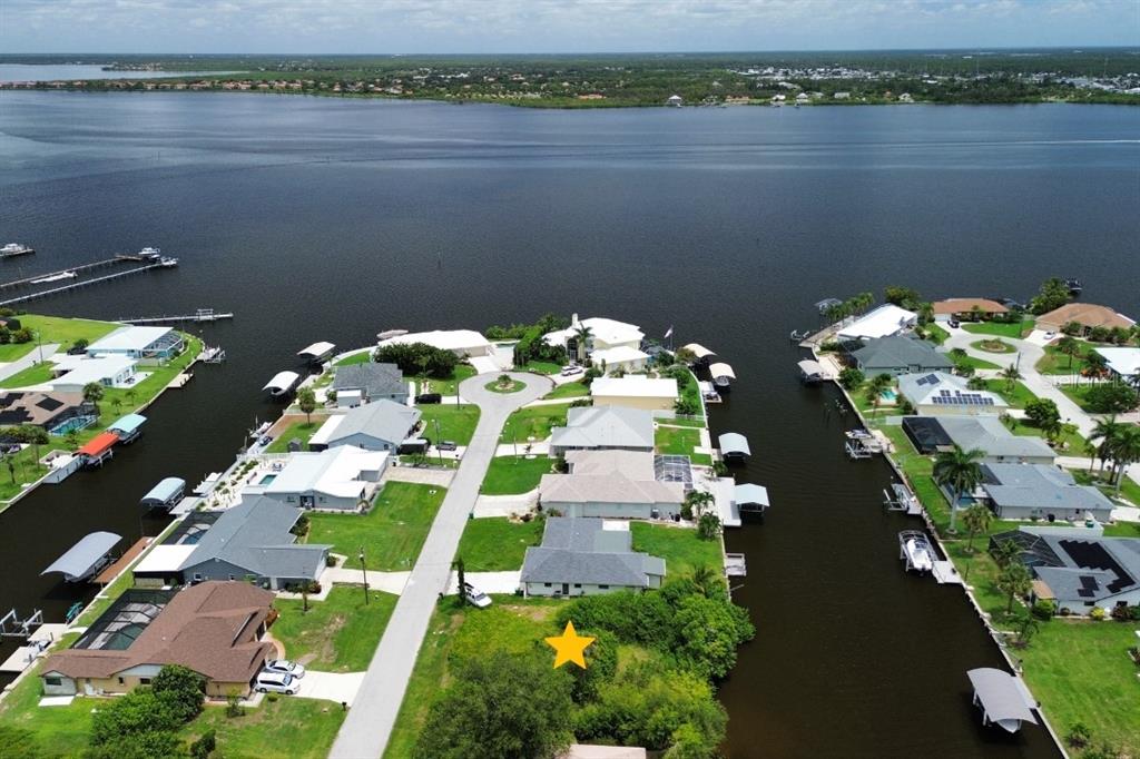 An aerial view shows a waterfront residential neighborhood with a vacant lot marked by a star — 5226 BOYLE TERRACE, PORT CHARLOTTE, FL