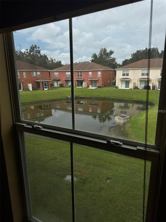 A view from a window looking out over a small pond and neighboring residential buildings — 6913 MARBLE FAWN PLACE, RIVERVIEW, FL