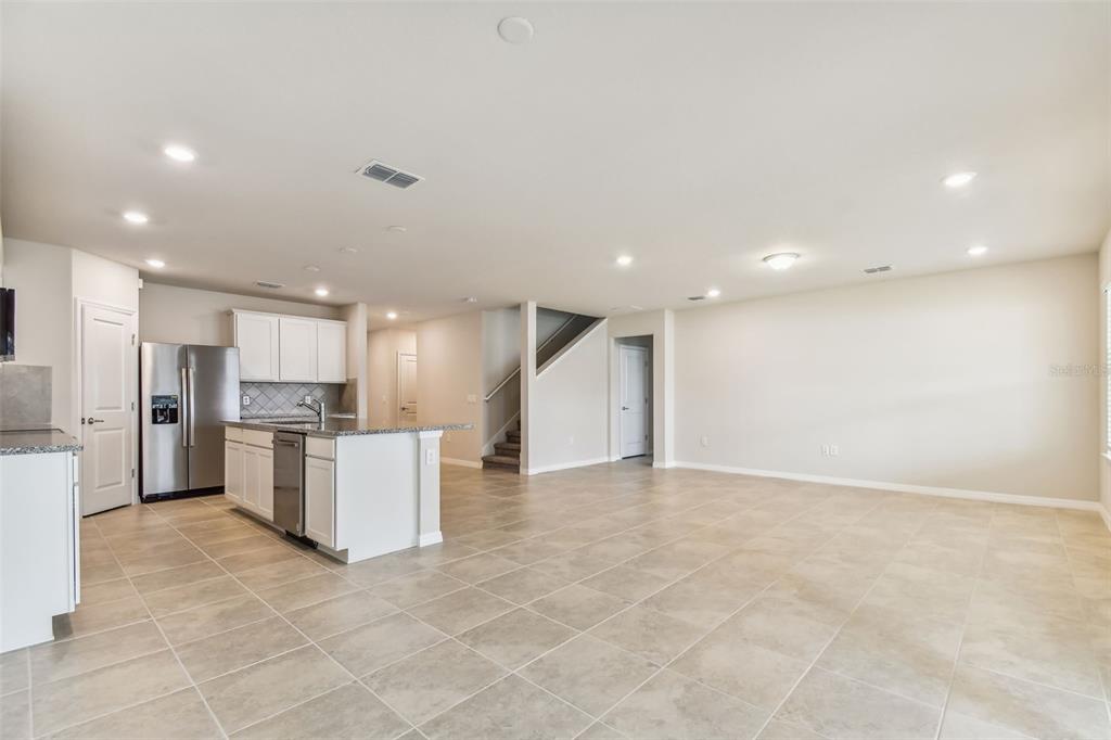 A kitchen island with a sink sits in a room with tile floors and stairs — 11250 SYCAMORE GLEN LOOP, THONOTOSASSA, FL
