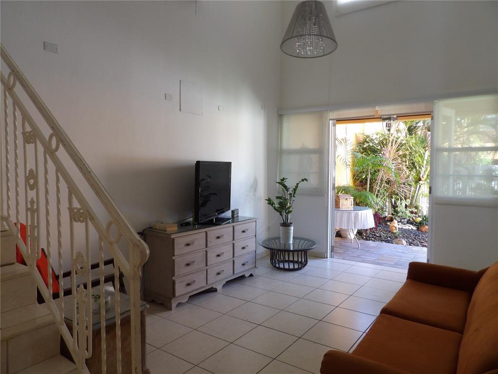 A living room with tile floors, a staircase, a television console, and a glass door — Brighton Boulevard A11, DORADO, PR