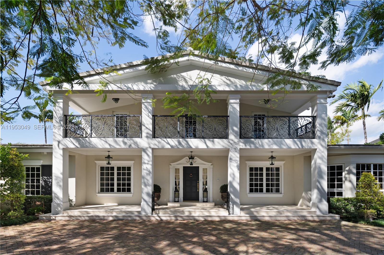 A two-story house features a white facade, large columns, and a black wrought-iron balcony — 4620 Granada Blvd, Coral Gables FL 33146, CORAL GABLES, FL