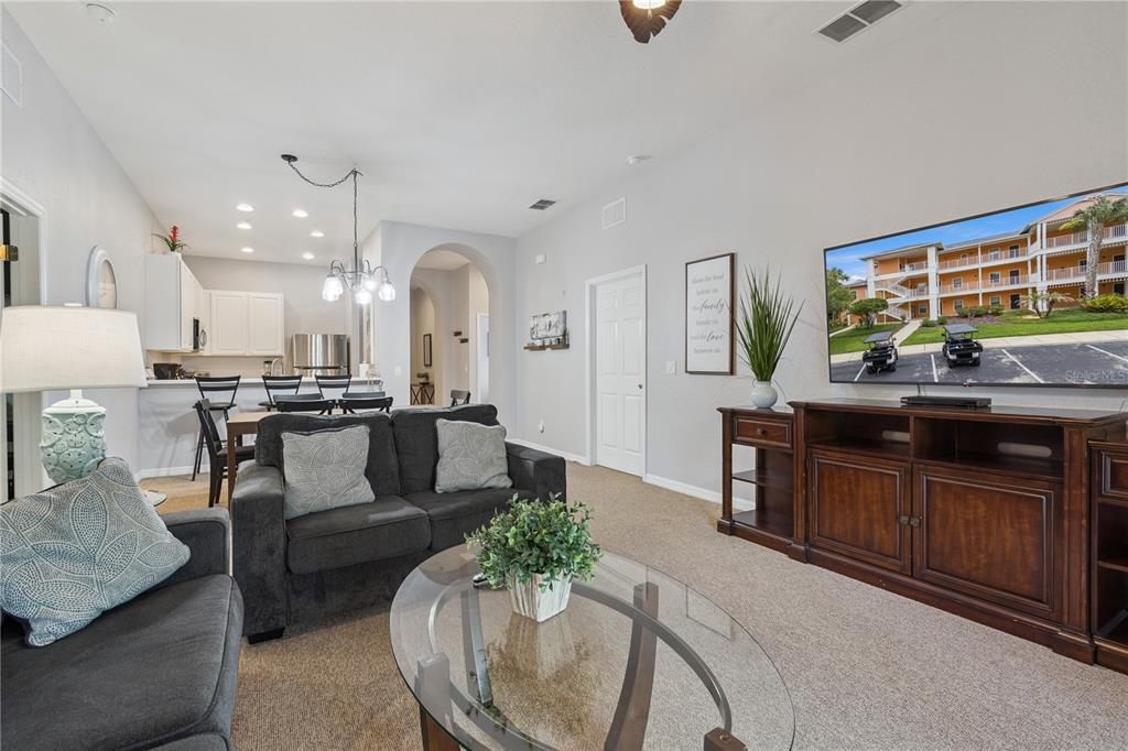 A living room with a dark sofa, glass coffee table, and a television on a console — 113 ANDROS AVENUE UNIT B16 U113, DAVENPORT, FL