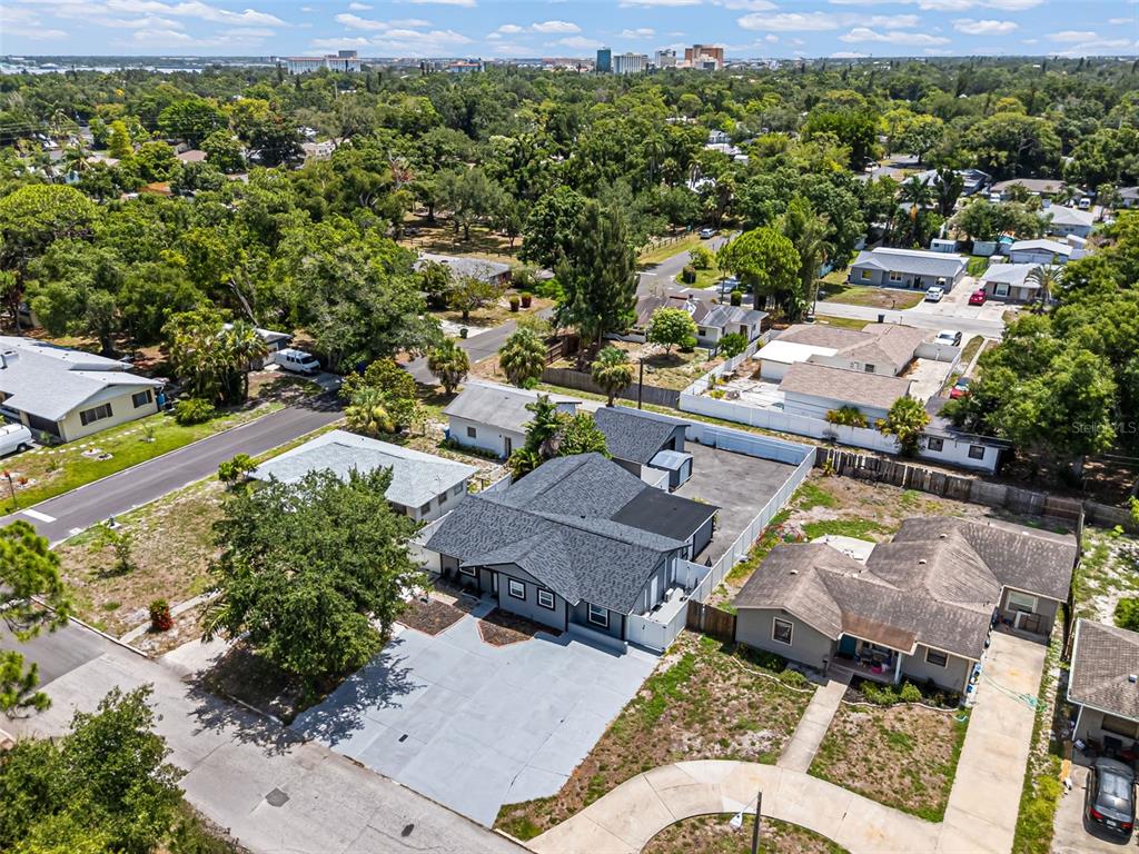 An aerial view shows a gray-roofed house with a large concrete driveway and surrounding neighborhood — 1305 29TH STREET W, BRADENTON, FL