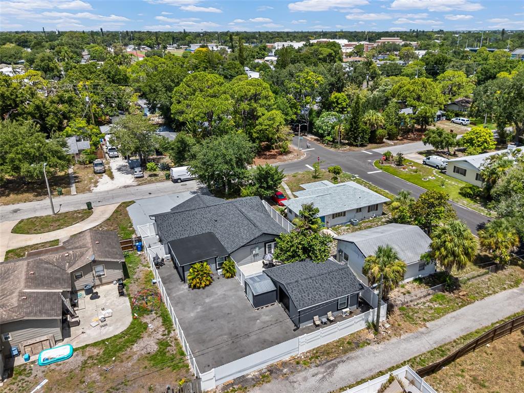An aerial view shows a residential property with a main house, detached garage, and fenced yard — 1305 29TH STREET W, BRADENTON, FL