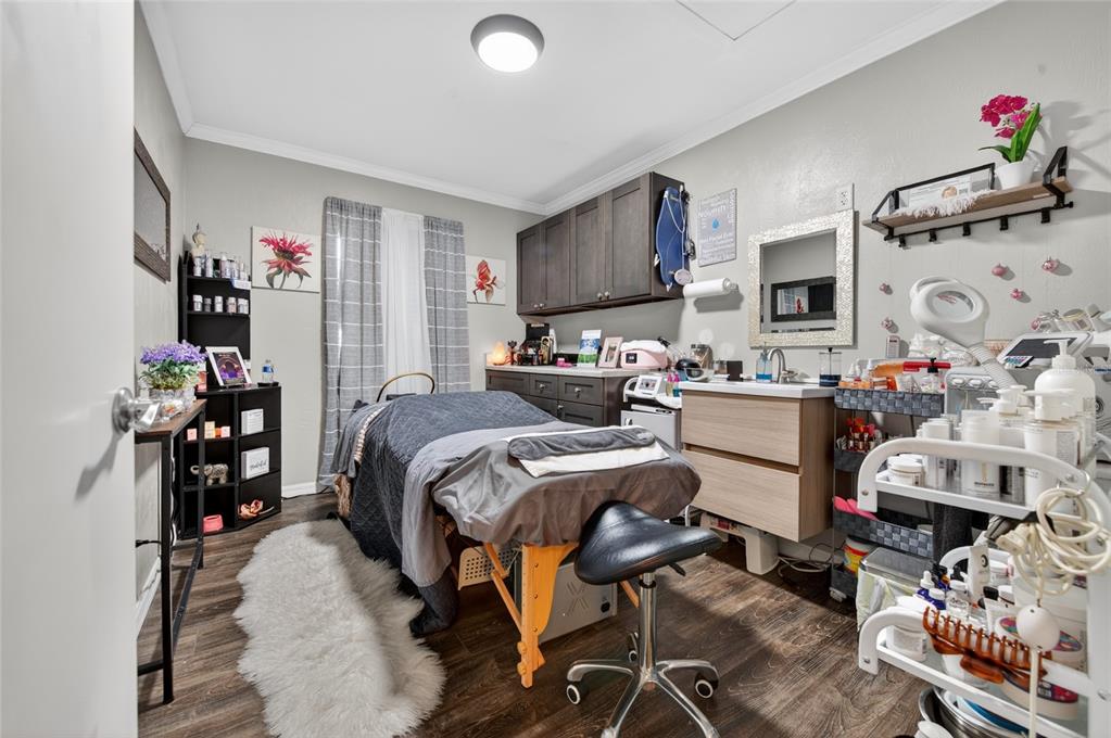 A small spa treatment room features a massage table, a rolling cart, and dark cabinetry — 555 W GRANADA BOULEVARD UNIT B7, ORMOND BEACH, FL