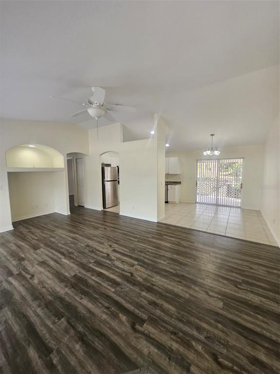 A living room with wood-look flooring, a ceiling fan, and an adjacent tiled dining area — 4138 AZORA STREET, NORTH PORT, FL