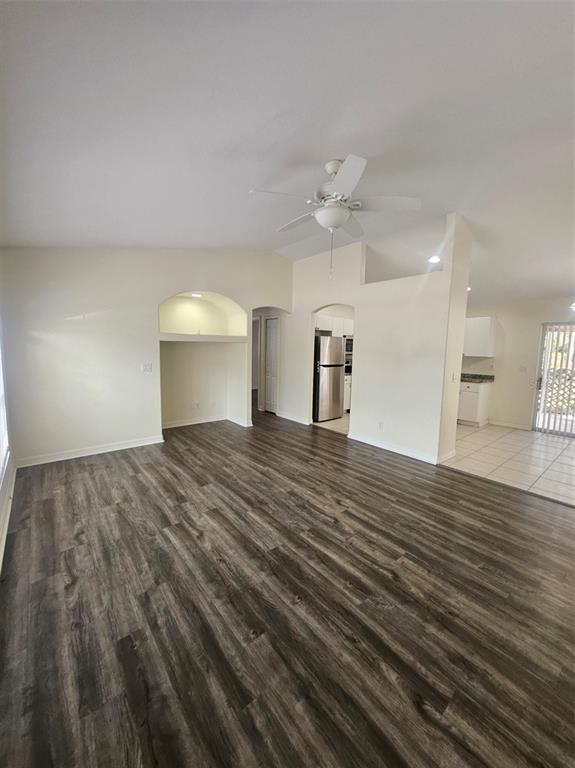 A living room with wood-look flooring, a ceiling fan, and an arched wall niche — 4138 AZORA STREET, NORTH PORT, FL