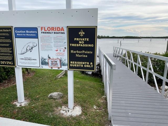 A sign for HarborPointe Marina stands next to a wooden dock leading into the water — 2042 N POINTE ALEXIS DRIVE, TARPON SPRINGS, FL