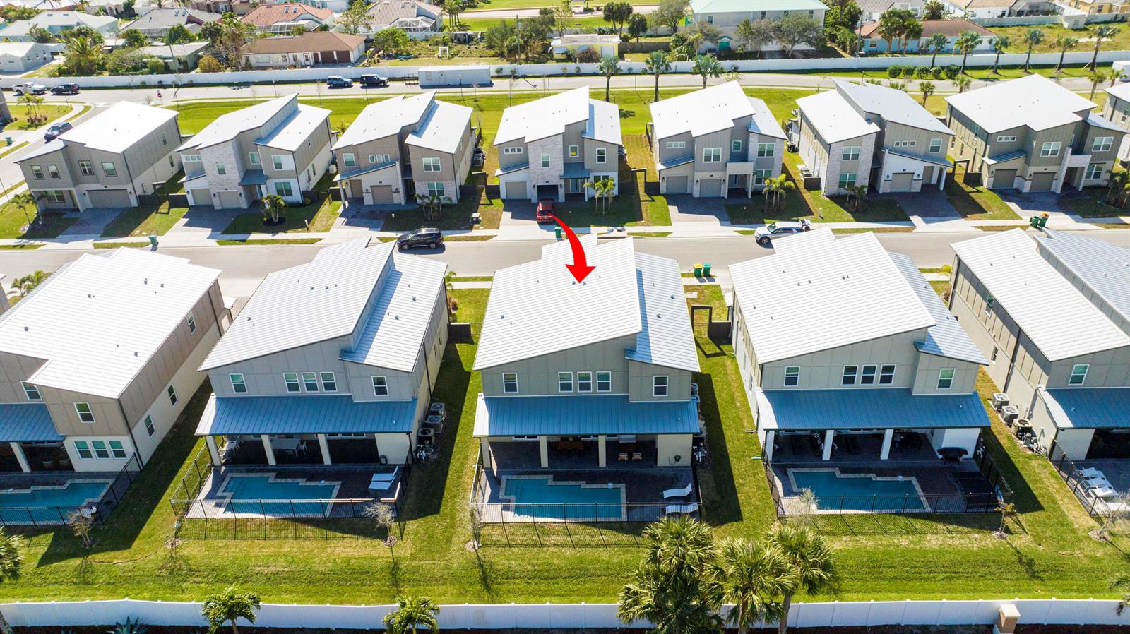 An aerial view shows a row of modern houses with metal roofs and private pools — 405 Strand Drive, Melbourne Beach FL 32951, MELBOURNE BEACH, FL