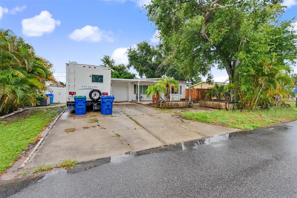 A white RV is parked on a concrete driveway in front of a single-story house — 824 67TH STREET S, ST PETERSBURG, FL