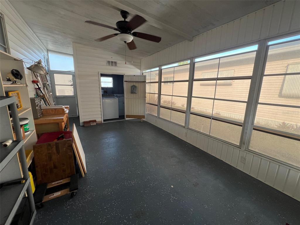 A sunroom with a ceiling fan, gray speckled flooring, and large windows overlooking a neighbor — 354 KING PALM STREET, LARGO, FL