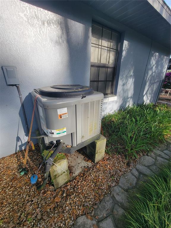 An outdoor air conditioning unit sits on concrete blocks next to a house exterior — 8028 SE 129TH PLACE, SUMMERFIELD, FL