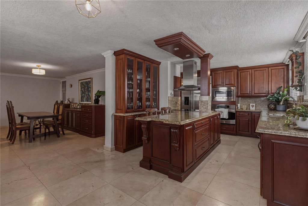 A kitchen with dark wood cabinets, a granite-topped island, and tile flooring — 15 CALLE TAFT UNIT 202, SAN JUAN, PR
