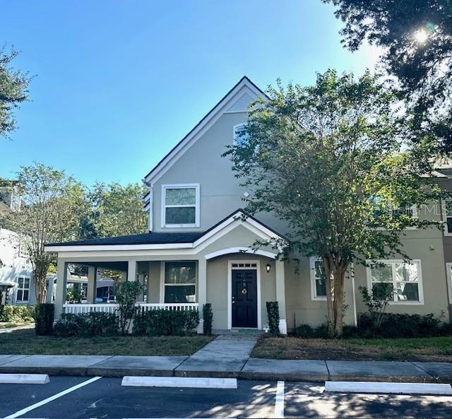 A two-story house with a front porch, a dark door, and a small yard — 3324 PARKCHESTER SQUARE BOULEVARD UNIT 102, ORLANDO, FL