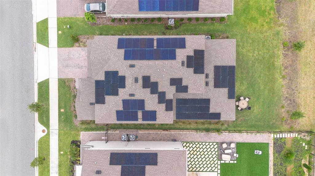 An aerial view shows two houses with solar panels installed on their shingled roofs — 11941 LANGUAGE WAY, ORLANDO, FL