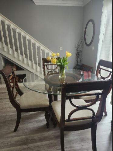 A dining area features a round glass table with four chairs near a white staircase — 2011 Madeira Drive, Weston FL 33327, WESTON, FL