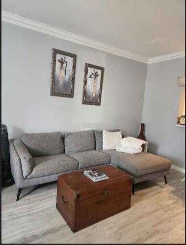 A living room features a grey sectional sofa, a wooden trunk coffee table, and wall art — 2011 Madeira Drive, Weston FL 33327, WESTON, FL