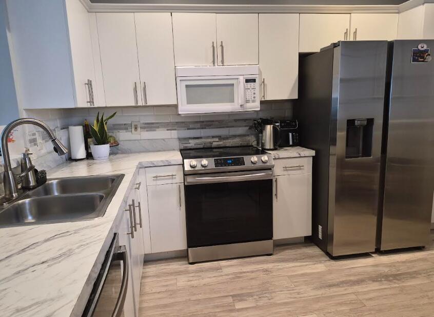 A kitchen with white cabinets, stainless steel appliances, and marble-patterned countertops — 2011 Madeira Drive, Weston FL 33327, WESTON, FL