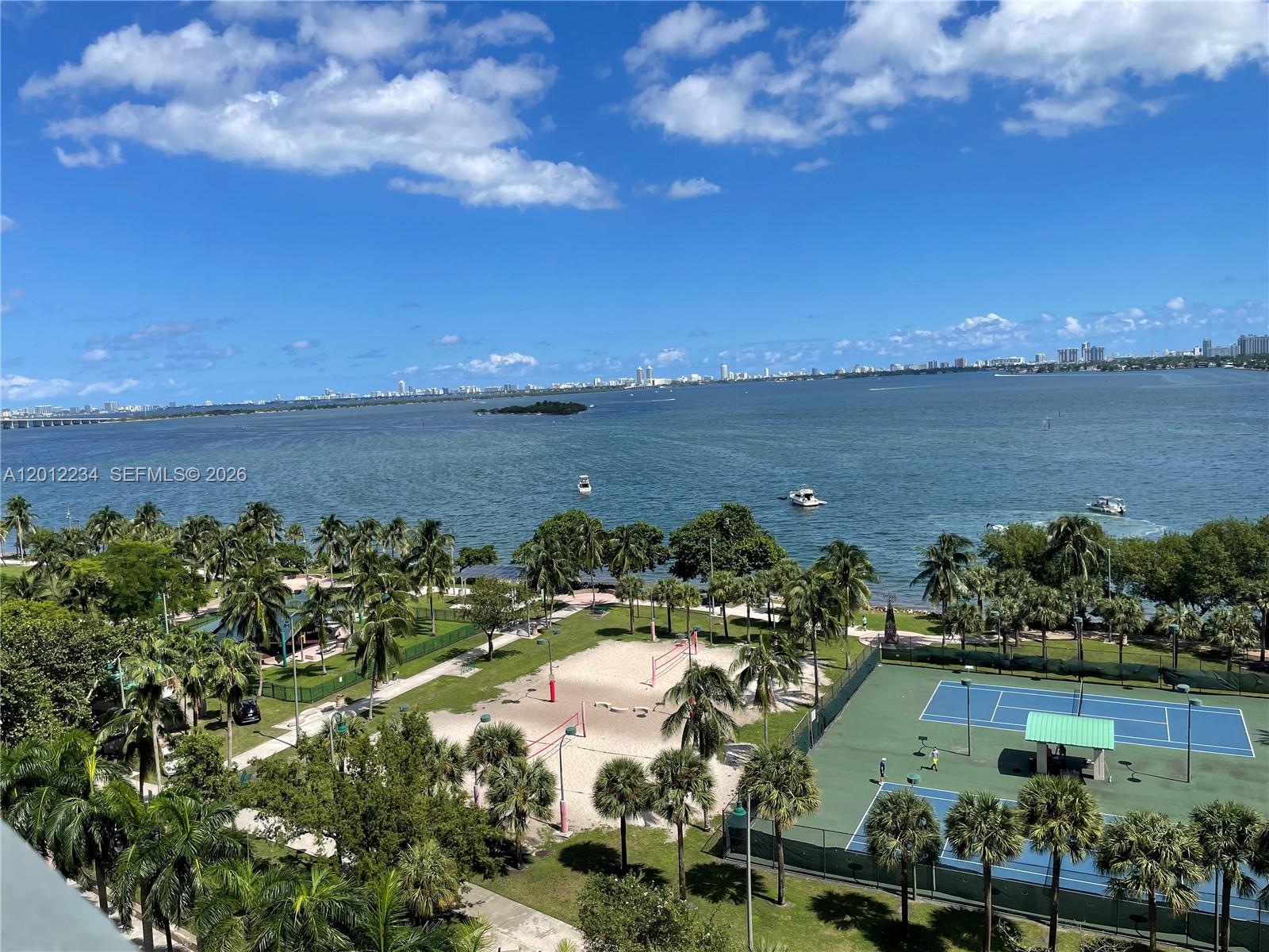 An elevated view of a park with tennis courts and palm trees overlooking the bay — 1750 N Bayshore Dr # 3403, Miami FL 33132, MIAMI, FL