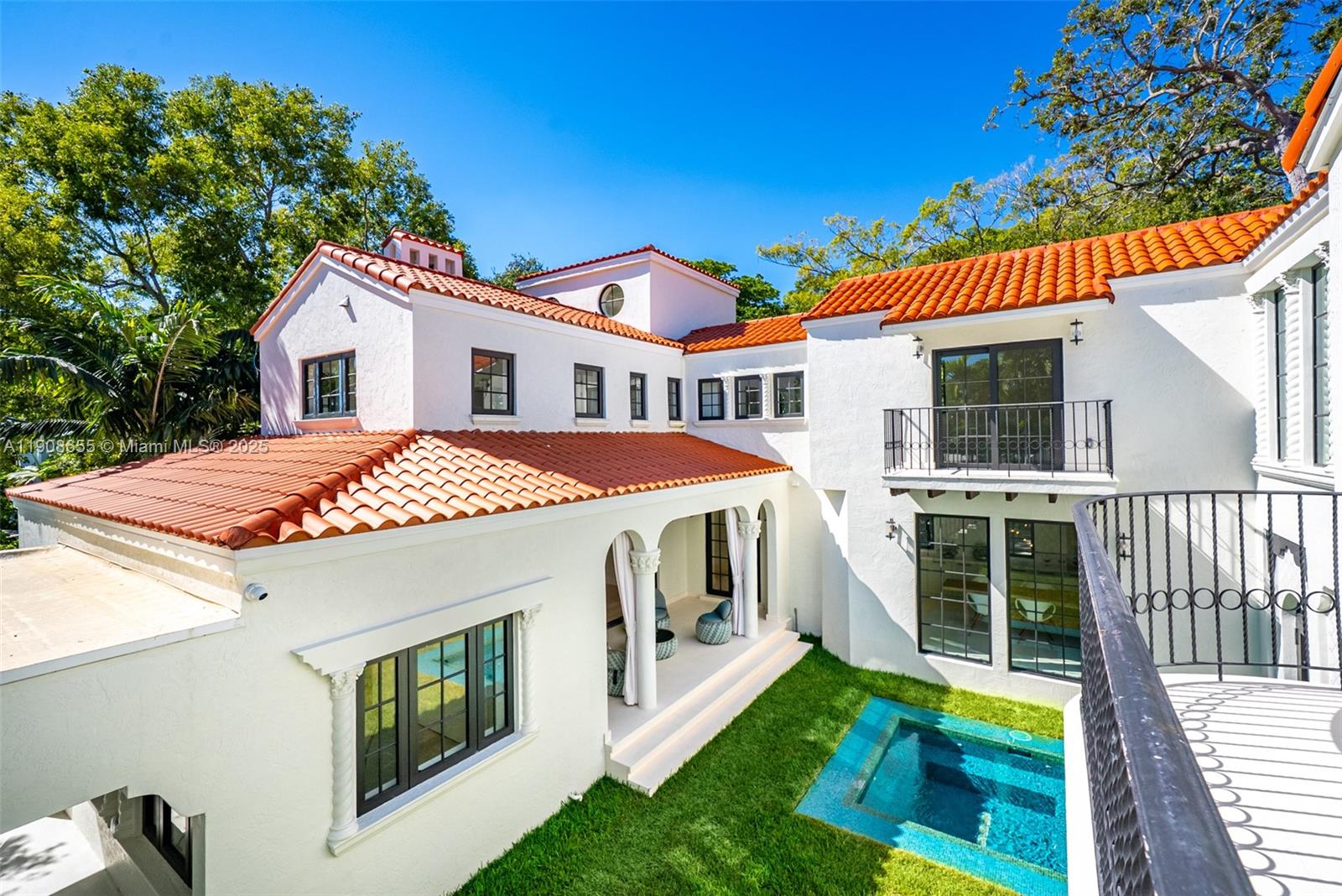 A white Mediterranean-style house with a red tile roof overlooks a small backyard pool — 601 NE 56th St, Miami FL 33137, MIAMI, FL