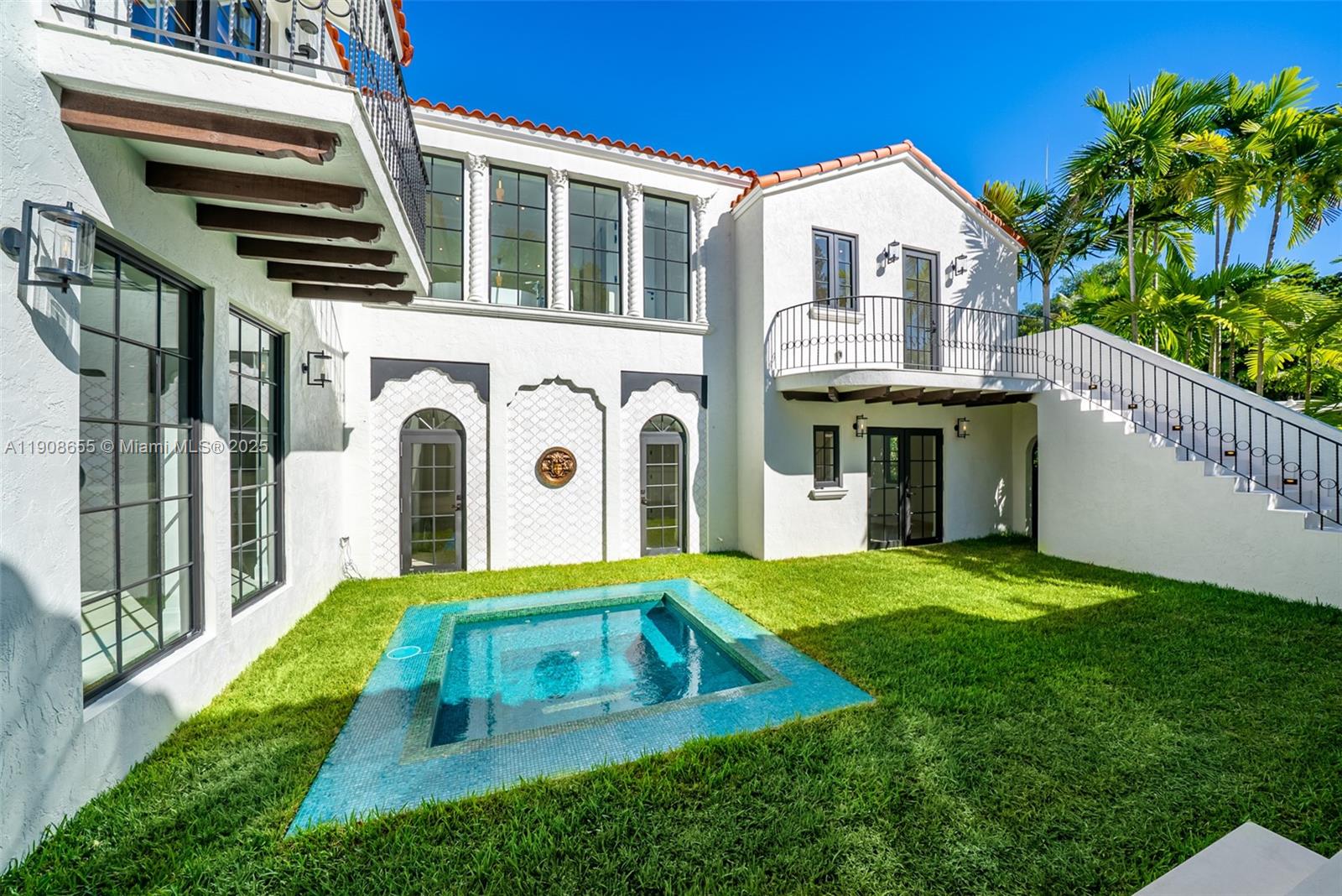 A white stucco house features a small rectangular pool set into a grassy backyard — 601 NE 56th St, Miami FL 33137, MIAMI, FL