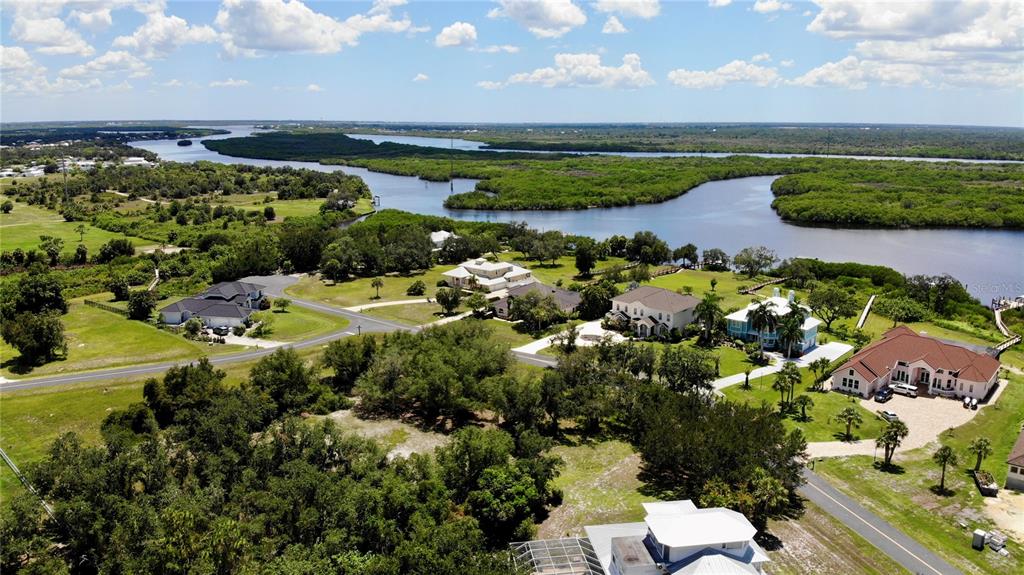 An aerial view shows several large houses situated along a winding river and marshland — 530 WOODSTORK LANE, PUNTA GORDA, FL