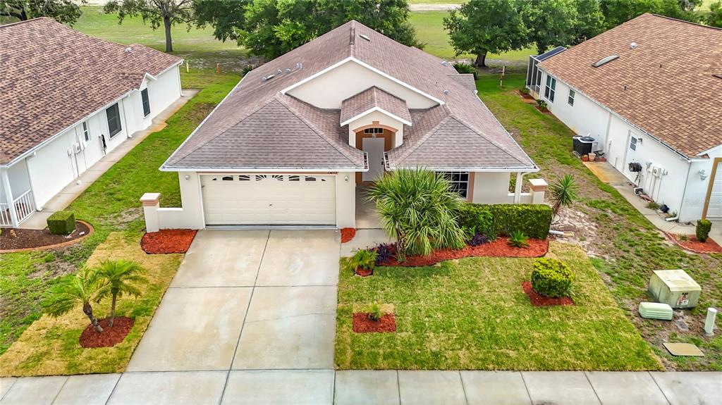 An aerial view of a single-story house with a two-car garage and landscaped yard — 13203 GOLF RIDGE PLACE, HUDSON, FL