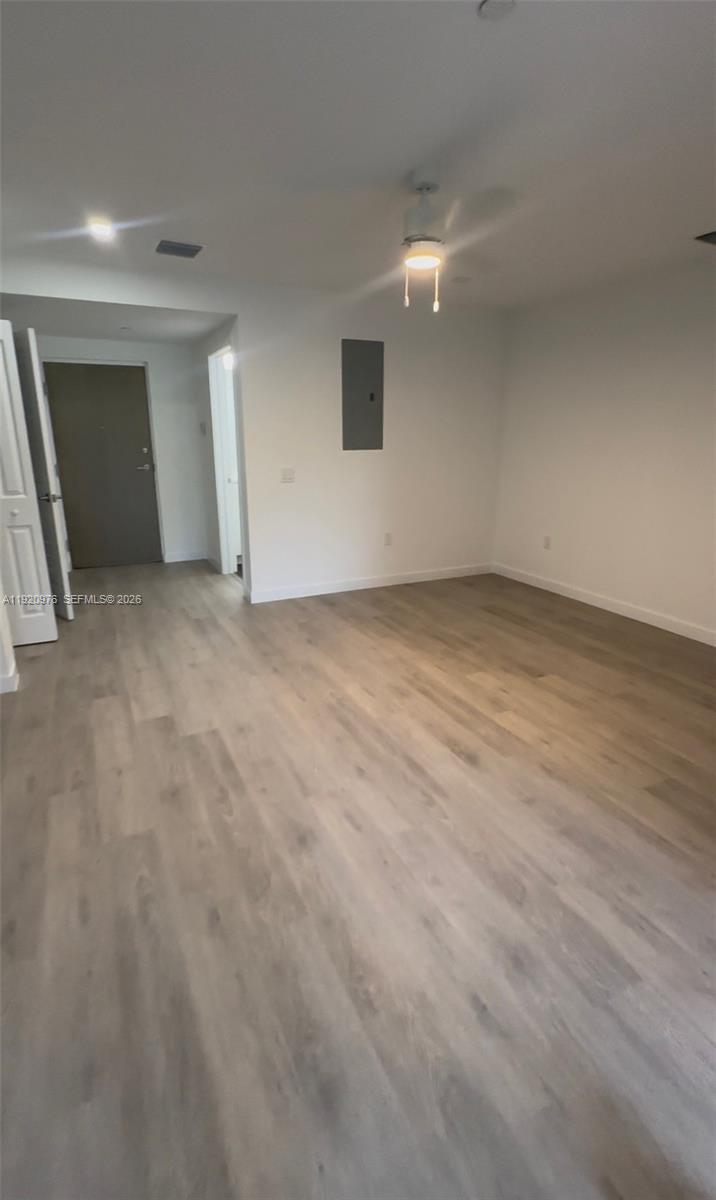 An empty room features light wood-look flooring, white walls, and a ceiling fan — 20 NE 19th Ave # 302, Pompano Beach FL 33060, POMPANO BEACH, FL