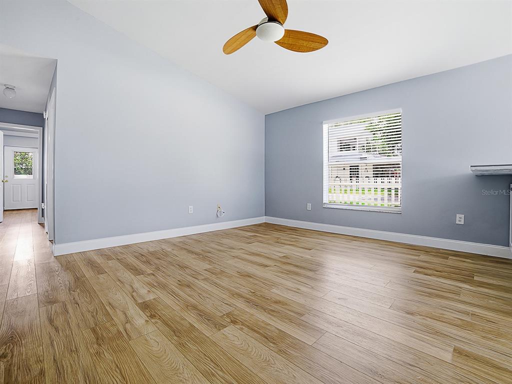 An empty bedroom features light blue walls, wood-look flooring, and a ceiling fan — 2741 S BROWN AVENUE, ORLANDO, FL
