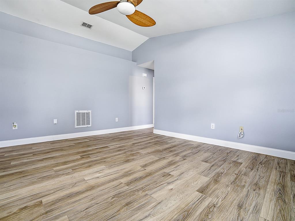 An empty room features light blue walls, wood-look flooring, and a ceiling fan — 2741 S BROWN AVENUE, ORLANDO, FL