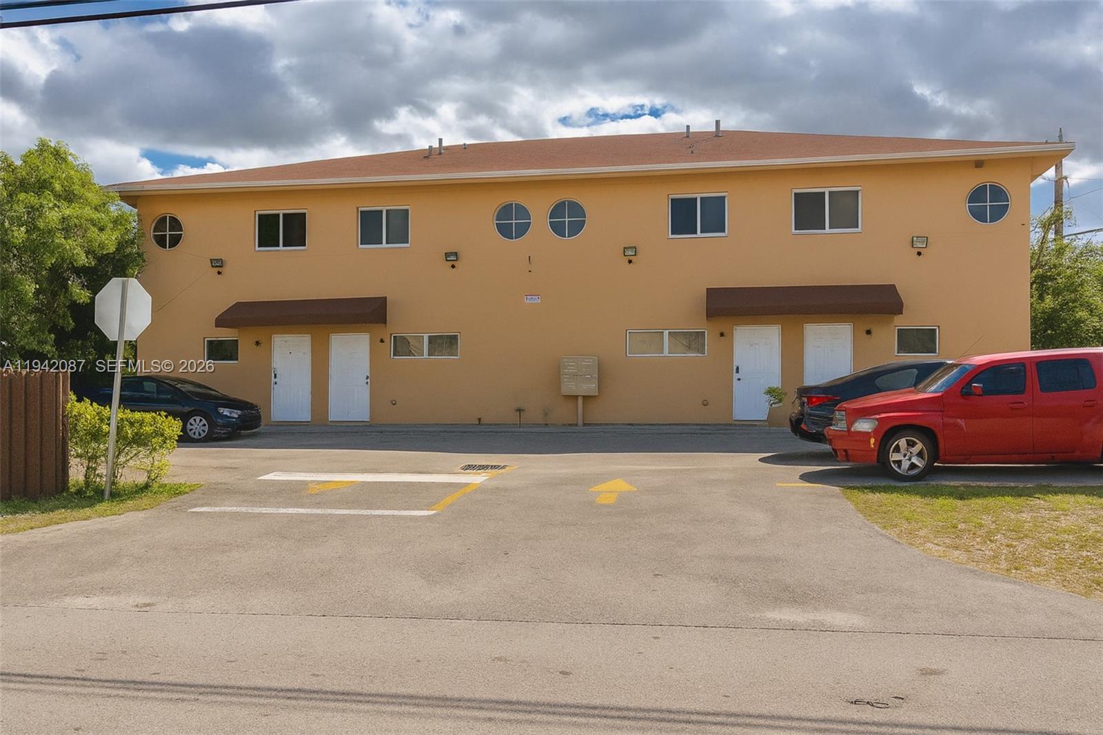 A two-story tan apartment building with a parking lot in front — 16585 NE 3 AVE, Miami FL 33162, MIAMI, FL