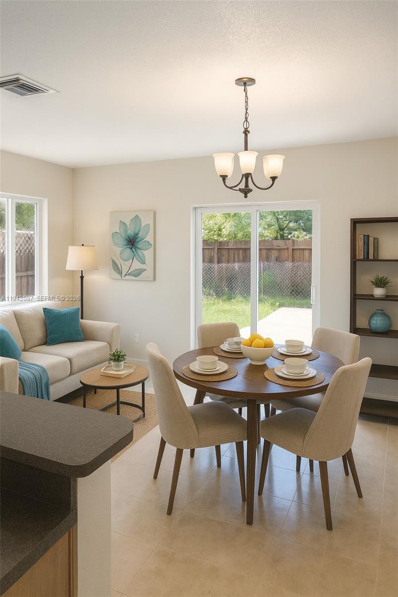 A dining area with a round table and a small living space with a sofa — 16585 NE 3 AVE, Miami FL 33162, MIAMI, FL