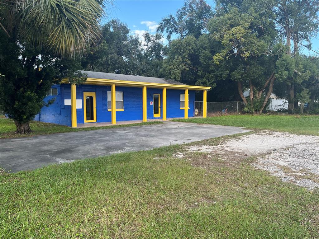 A one-story blue building with yellow trim and a covered porch sits on a lot — 805 FERGUSON DRIVE, ORLANDO, FL