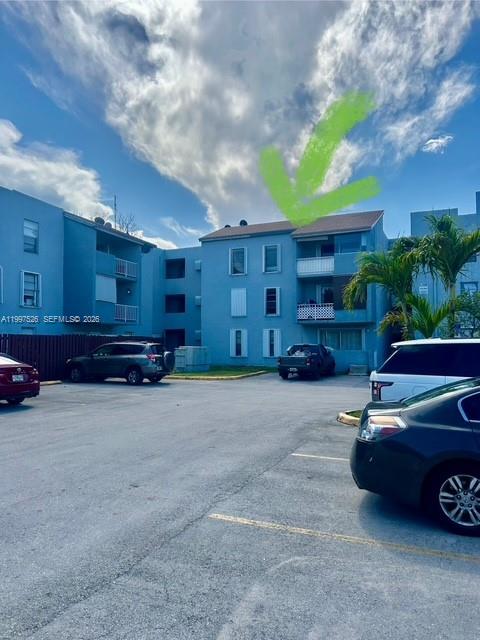 A multi-story blue apartment building with a parking lot in the foreground — 1725 W 60th St # F316, Hialeah FL 33012, HIALEAH, FL